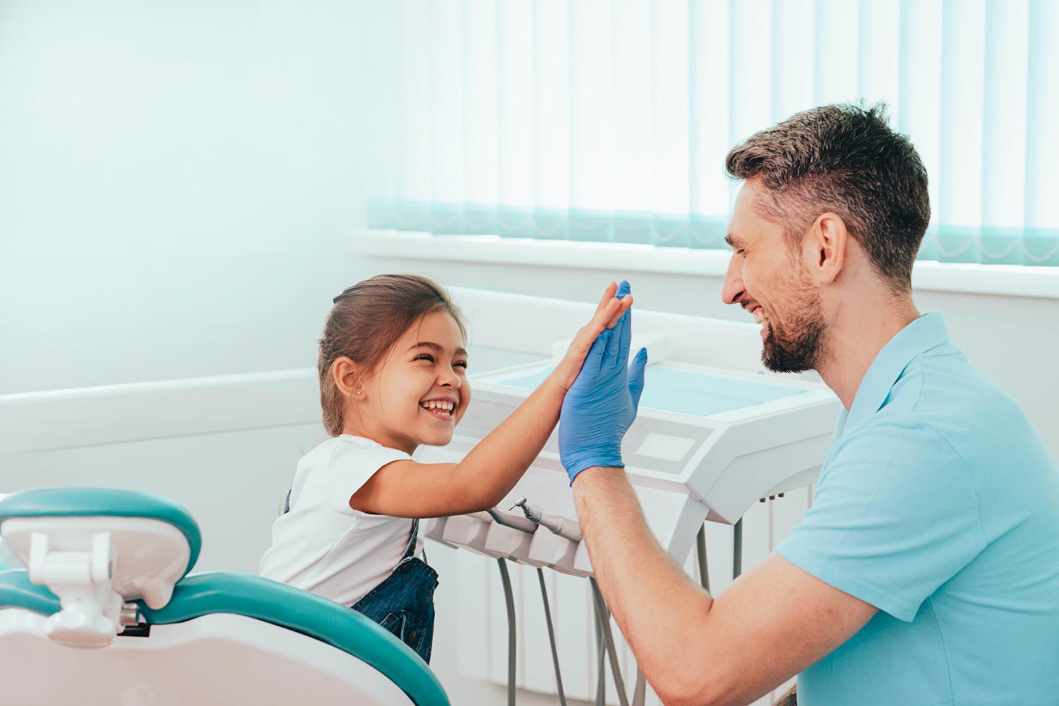 Tandläkare gör high five med ett barn